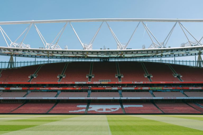 Un gran estadio con un campo verde y un cielo de fondo.